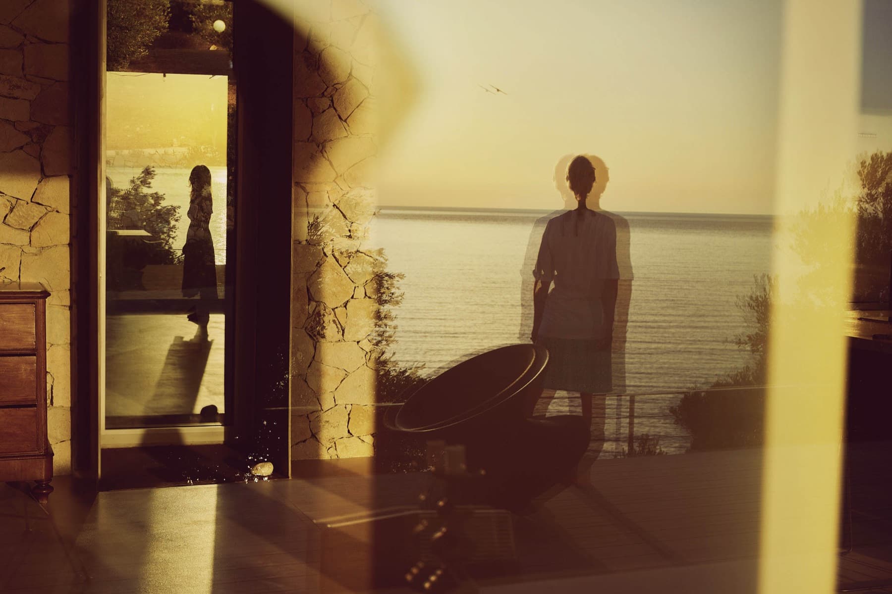 Silhouette in a doorway against the evening sea